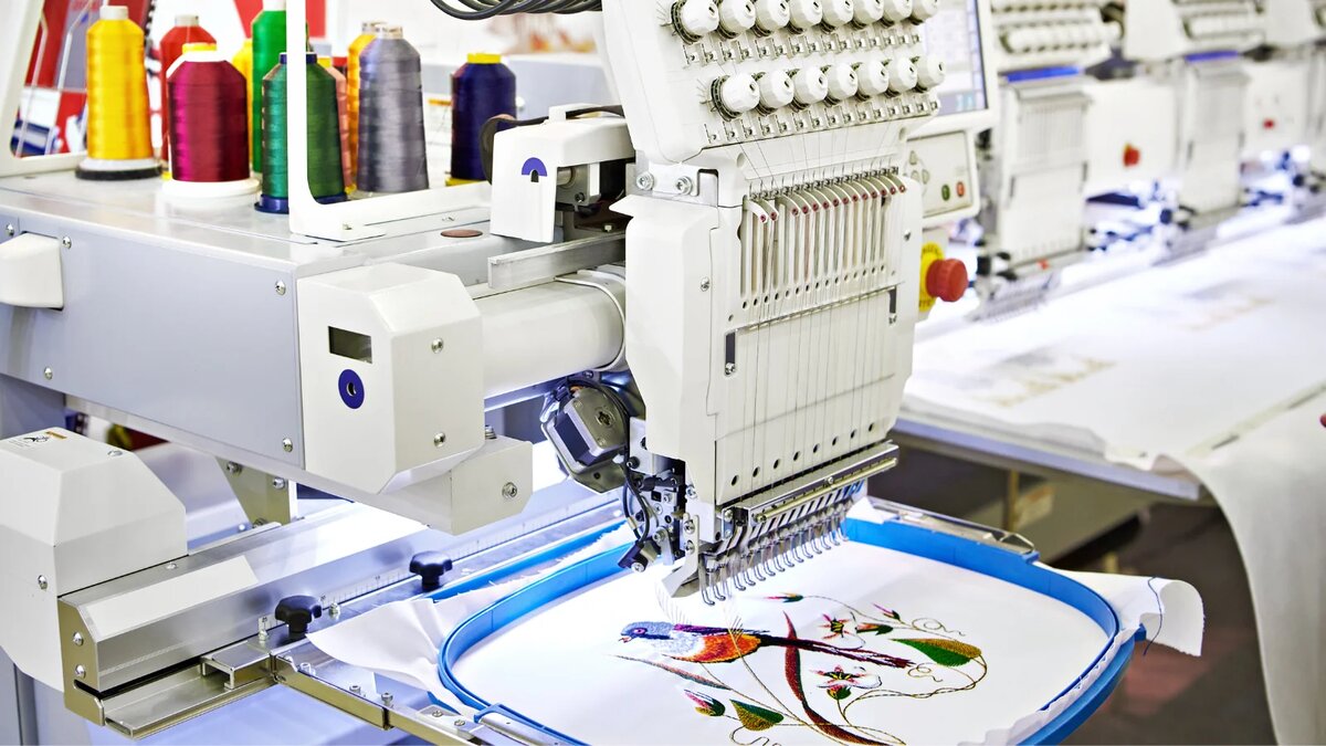 Máquina de bordar multicabezal creando diseño de pájaro colorido