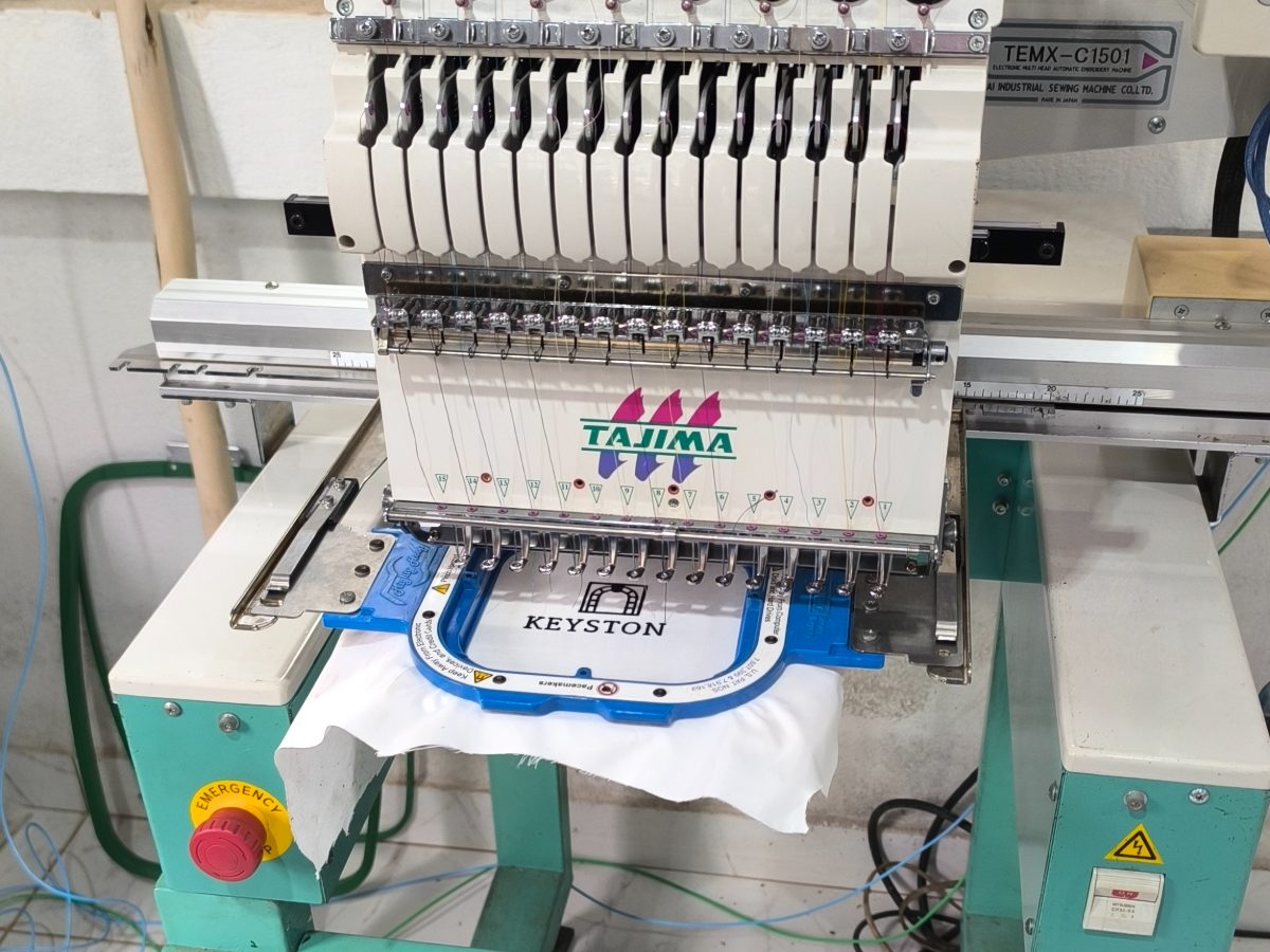 Tajima embroidery machine with a hooped garment ready for a test run